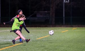 Two young women playing football 