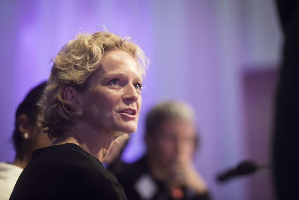 A white woman aged 50-60 speaking on a conference panel