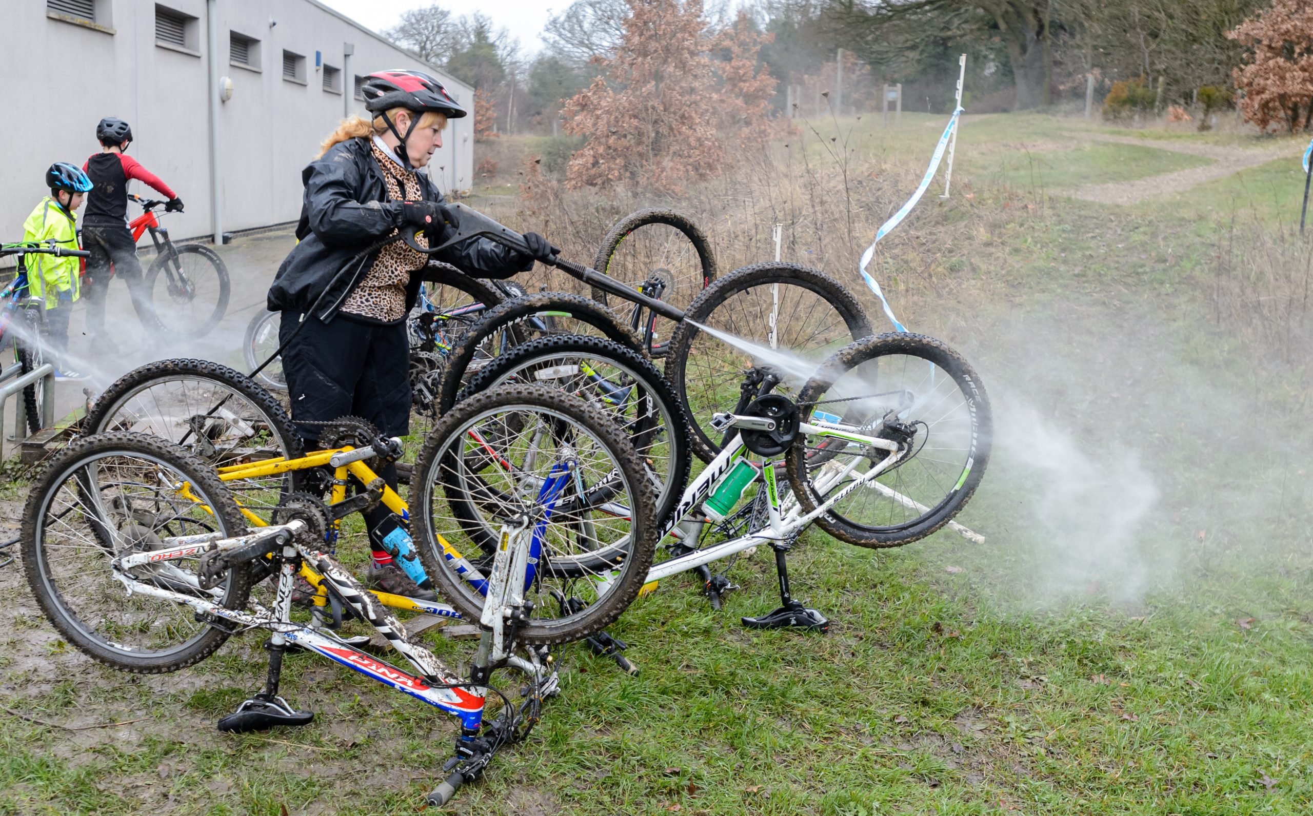 Woman hosing down mountain bikes to clean them