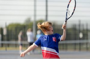 Young white girl playing tennis