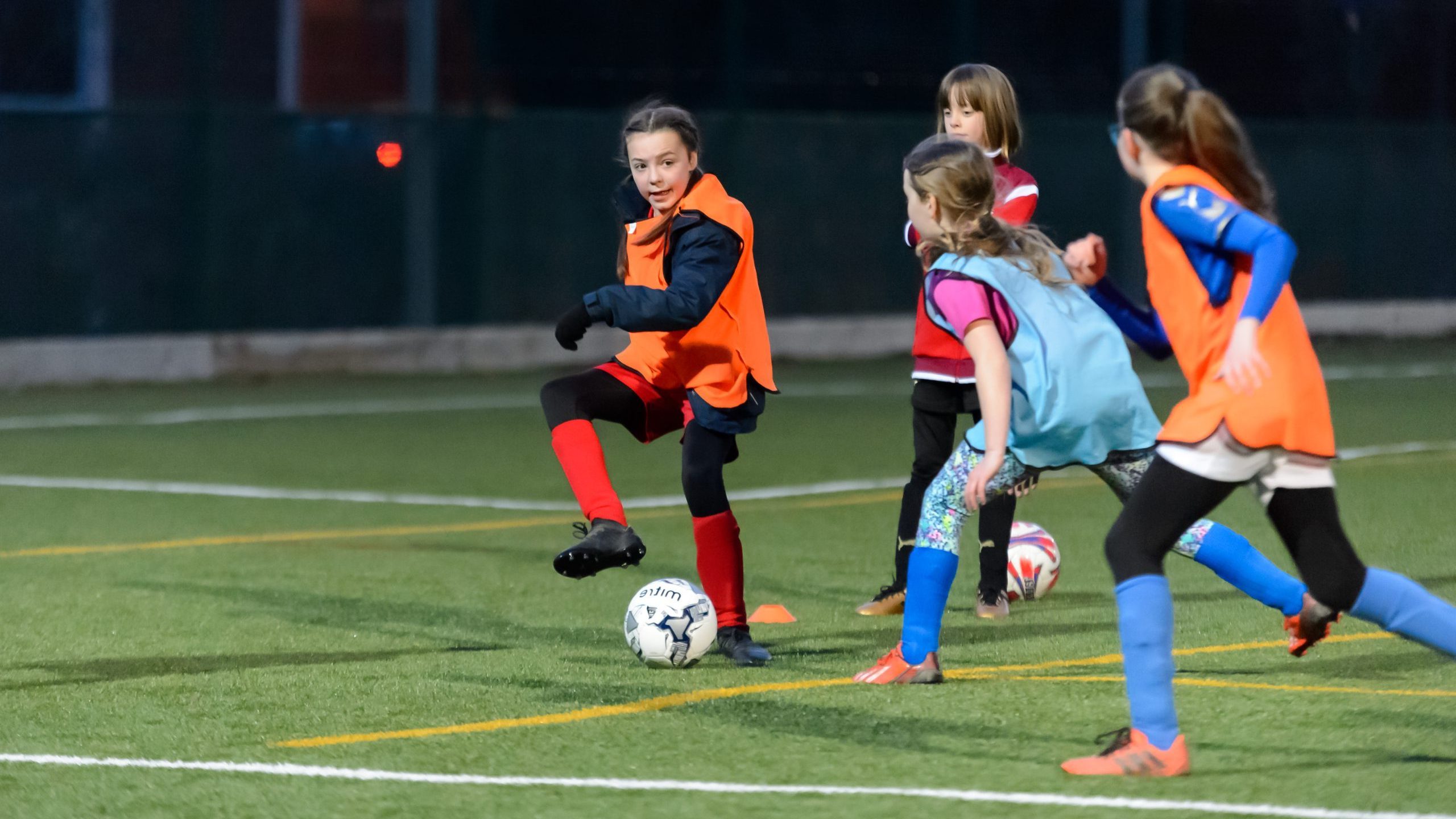 A group of young girls playing football