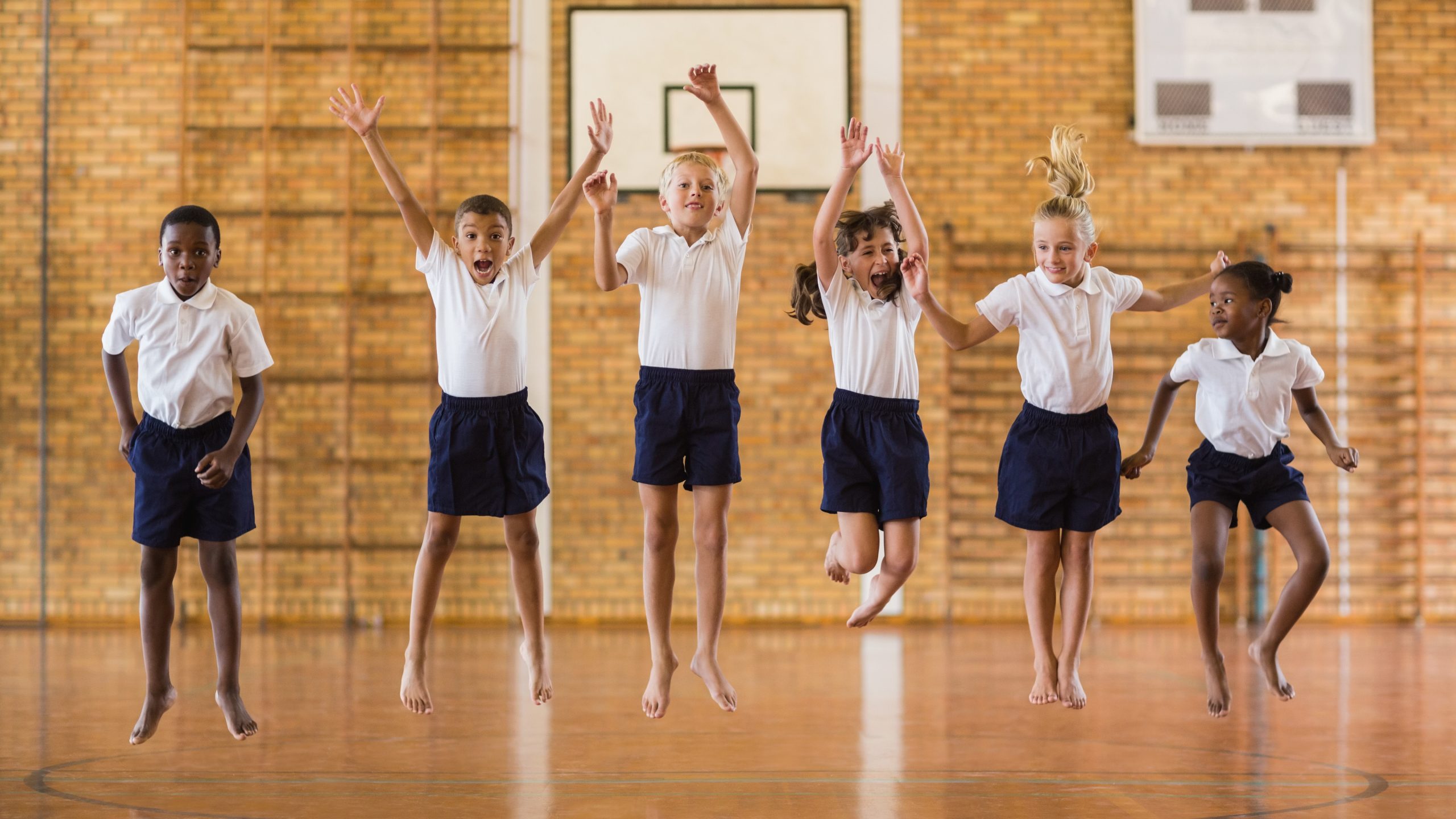 Group of students jumping in school gym