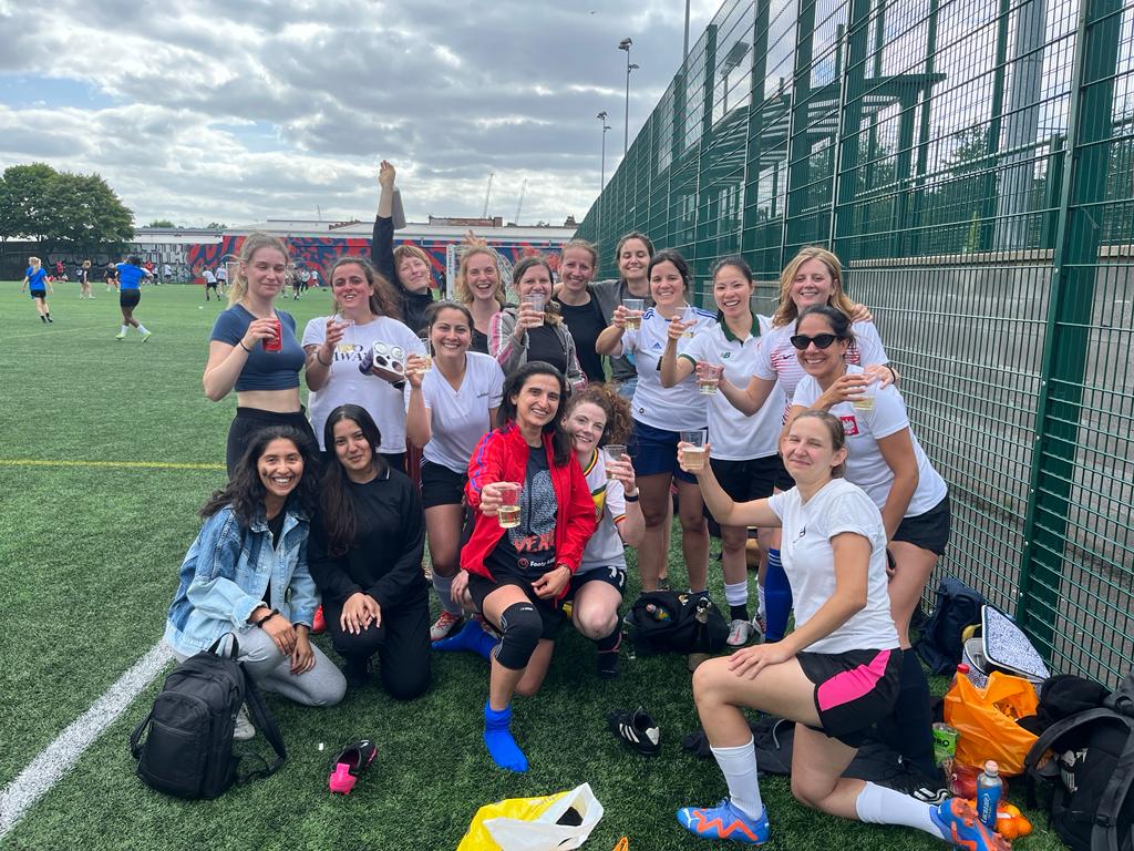 A group of girls celebrating on a football pitch