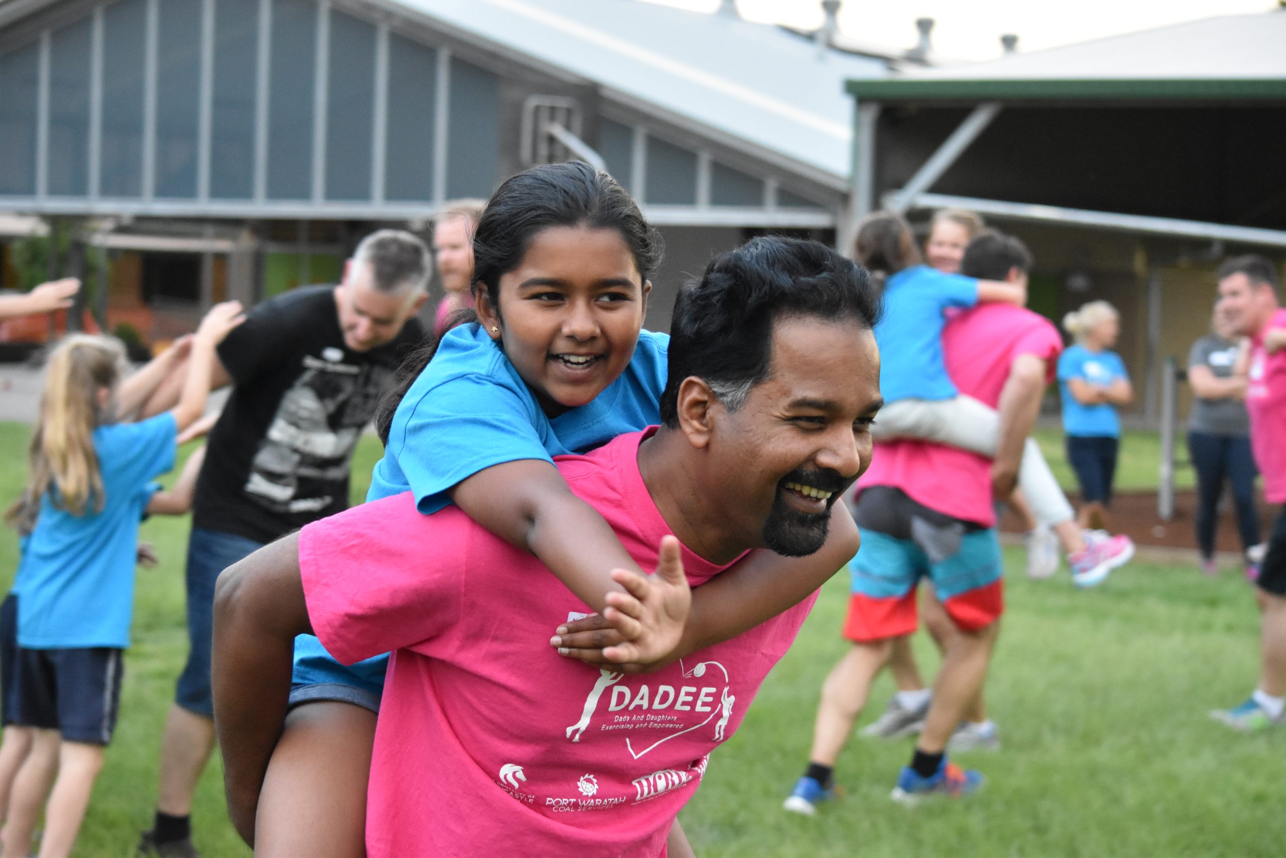 a dad giving his daughter a piggy back