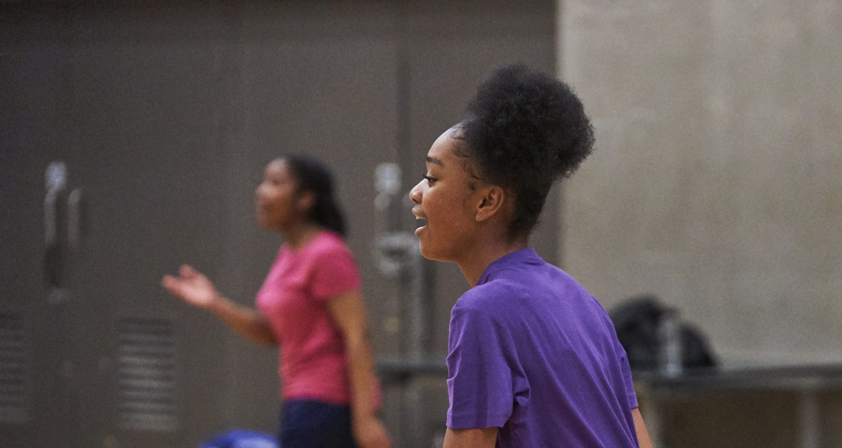 Three black teenagers having fun in their school sports hall