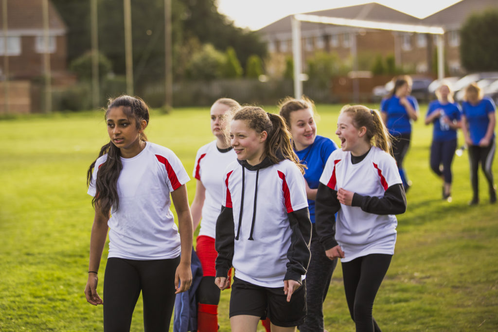 A group of rugby teen girls, setting up the pitch for a few warm ups before the big game