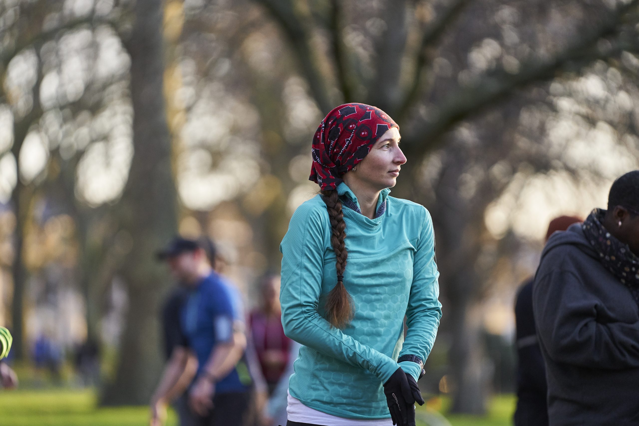 White woman with long brown hair aged 30-40 shivering before starting a running race