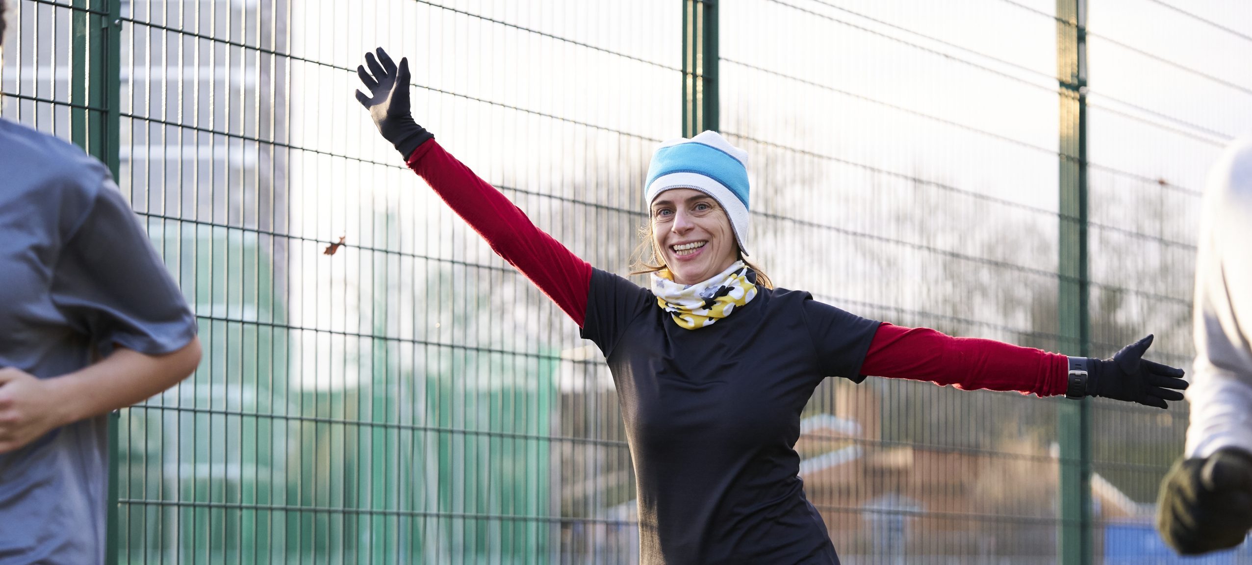 White woman running with her arms outstretched