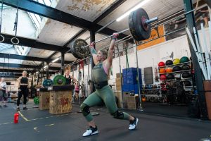 woman aged 30-40 lifting a weight above her head