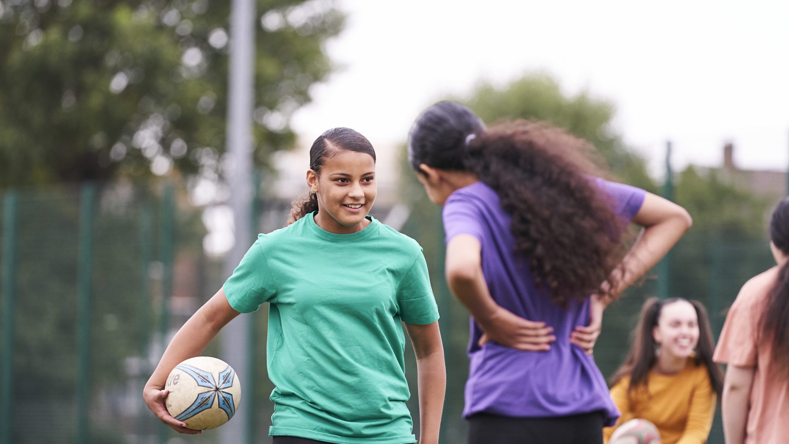 Two teenage girls playing rugby