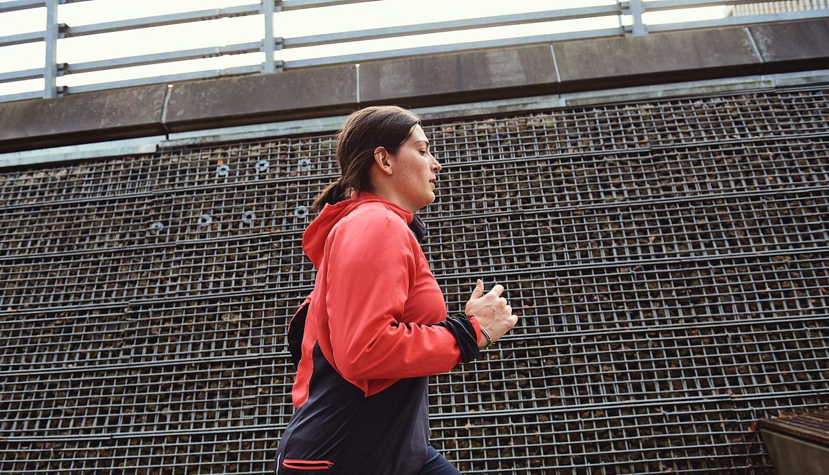 White woman aged 25-35 running with warm layers on